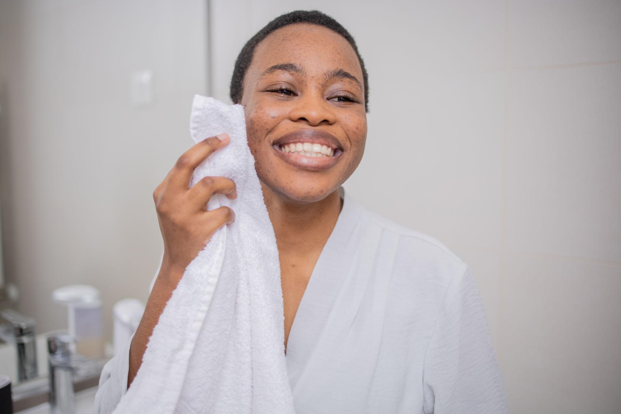 Woman with towel drying her face, smiling